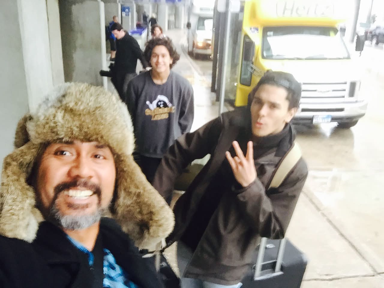 Dad with McCann Jr. and Josiah at the airport in a winter hat