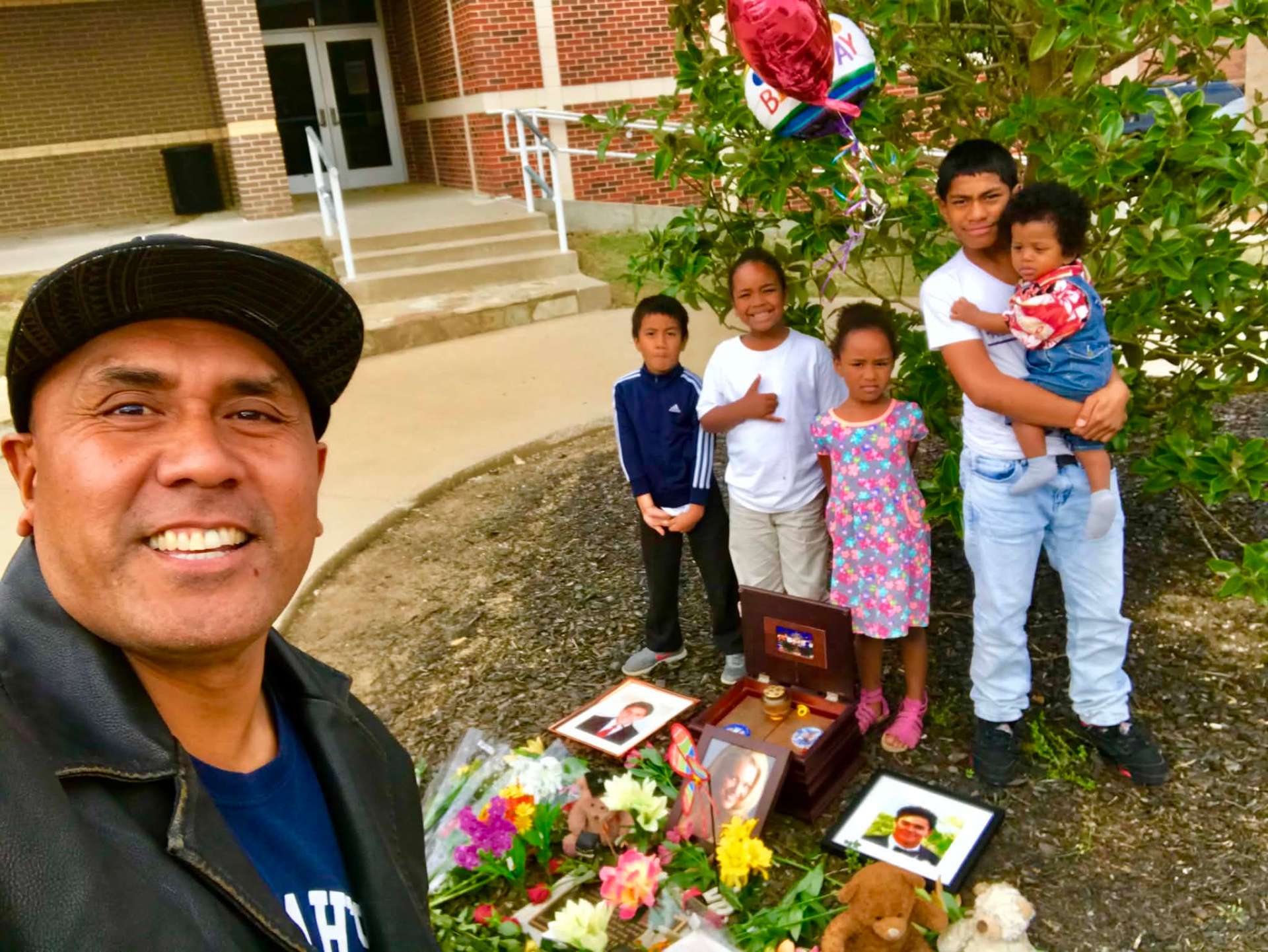 Dad with young family at Josiah's memorial tree with birthday balloons
